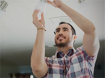 smiling man changing lightbulb